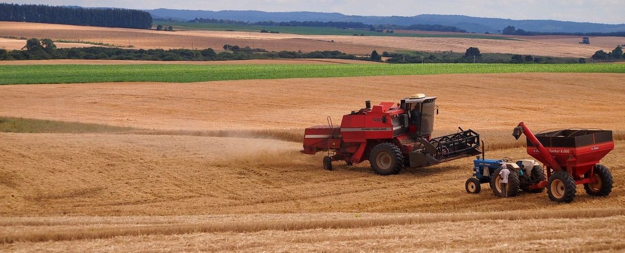 Colheitadeira e trator trabalham em uma lavoura durante a colheita, em Entre Rios, no Brasil.