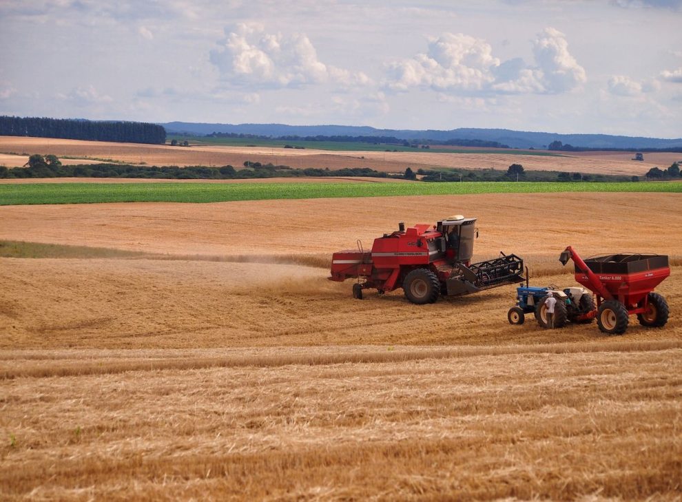 Colheitadeira e trator trabalham em uma lavoura durante a colheita, em Entre Rios, no Brasil.