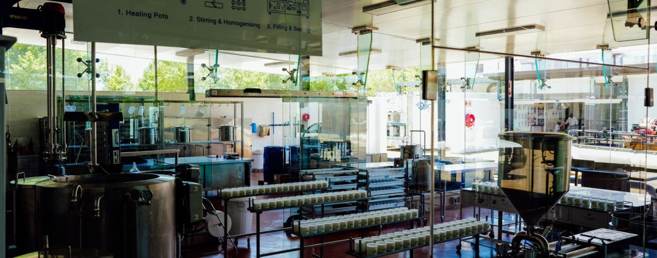 Interior de uma moderna unidade industrial de alimentos, com máquinas e uma linha de processamento.