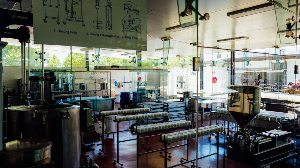 Interior de uma moderna unidade industrial de alimentos, com máquinas e uma linha de processamento.