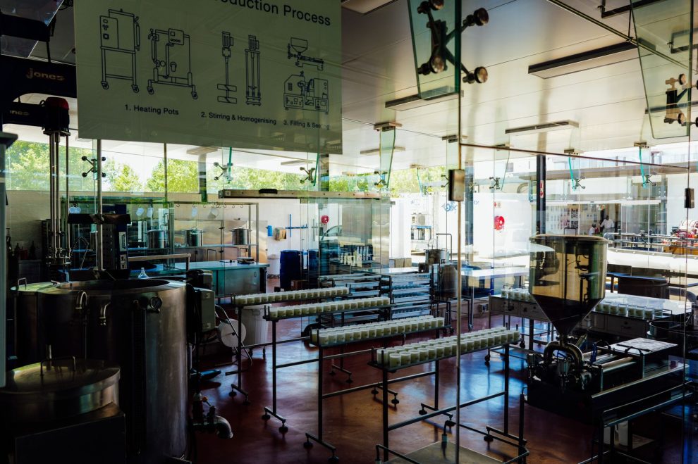 Interior de uma moderna unidade industrial de alimentos, com máquinas e uma linha de processamento.